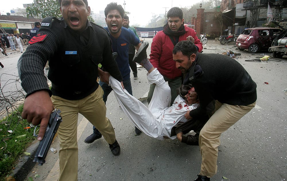 Pakistani police officers and volunteers rush an injured man to a hospital after a bombing in Lahore, Pakistan.