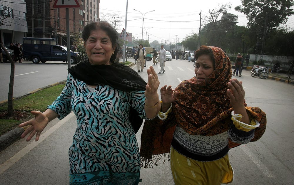 Pakistani women run following a bombing in Lahore, Pakistan.