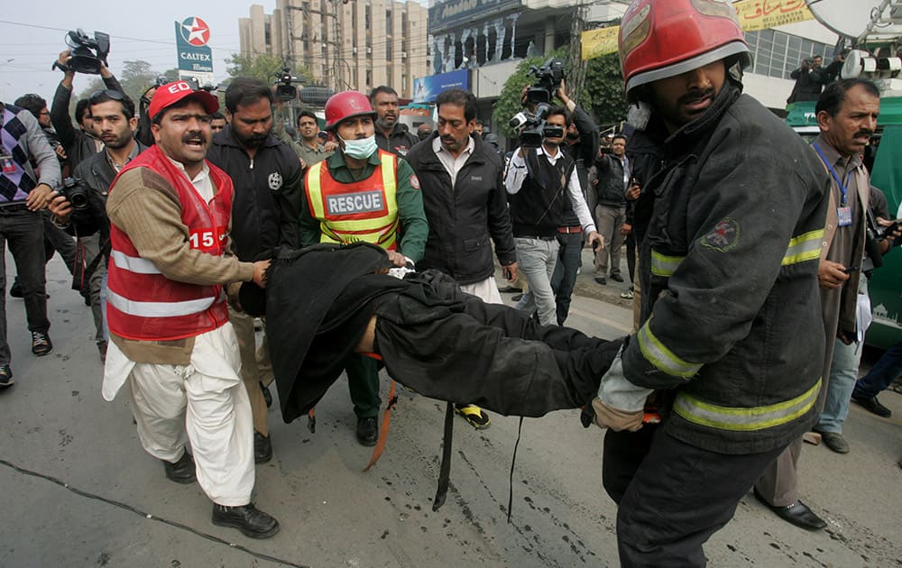 Pakistani rescue workers rush an injured person to a hospital after a bombing in Lahore, Pakistan.