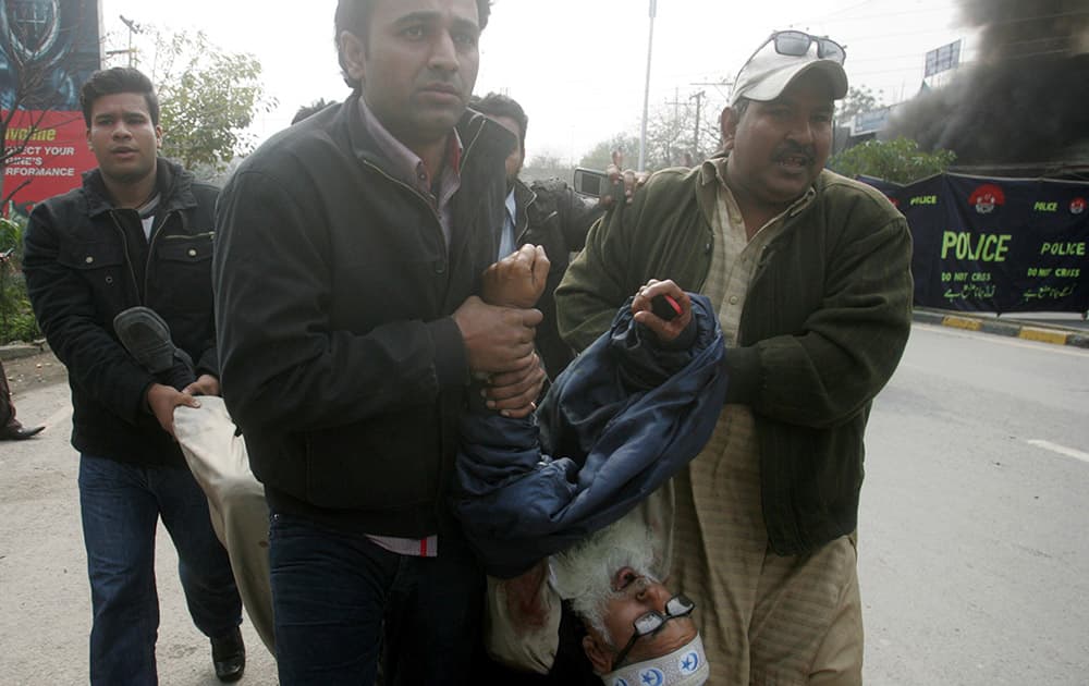 Pakistani volunteers rush an injured person to a hospital after a bombing in Lahore, Pakistan.