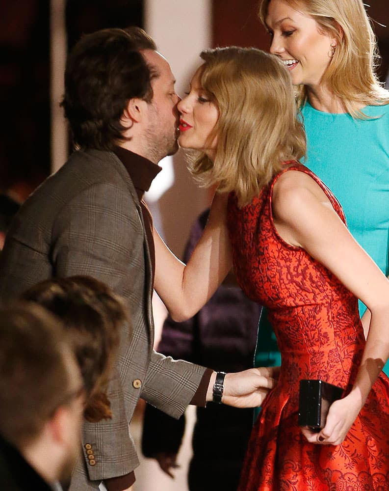 Singer/songwriter Taylor Swift plants a kiss on the cheek of American fashion writer and Harper's Bazaar editor-at-large Derek Blasberg after arriving for the Oscar de la Renta Fall 2015 collection in New York.