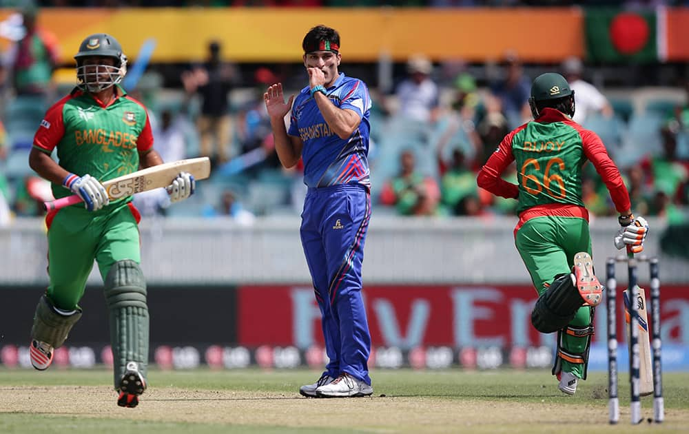 Afghanistan bowler Hassan Hamid, watches as Bangladesh batsmen Iqbal Tamim and Haque Anamul score runs during their Cricket World Cup Pool A match in Canberra, Australia.