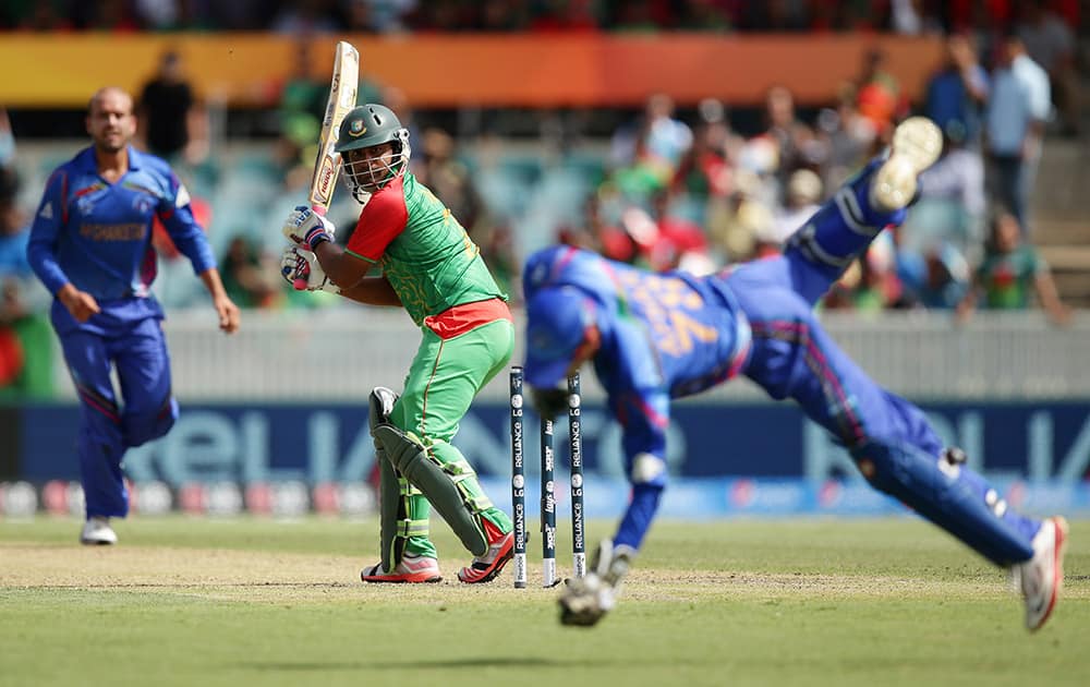 Bangladesh batsman Iqbal Tamim watches as Afghanistan’s wicketkeeper Zazai Afsar, takes a catch to dismiss him for 19 run during their Cricket World Cup Pool A match in Canberra, Australia.