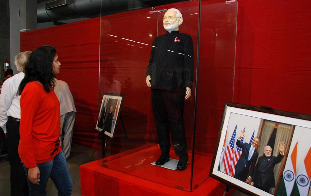 A visitor looks at Prime Minister Narendra Modi’s controversial pinstripe monogrammed bandhgala suit during its auction in Surat.