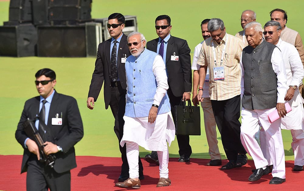 Prime Minister Narendra Modi with Defence Minister Manohar Parrikar and Karnataka Governor Vajubhai Vala arrives for the inauguration of the Aero India 2015 event at Yelhanka Air Base in Bengaluru.