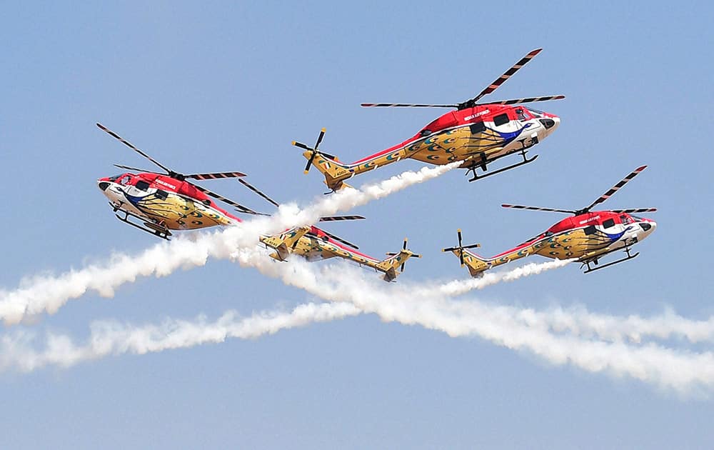 Indian Air Forces’ helicopter display teams’ 'Sarang' performs during the inauguration of the Aero India 2015 event at Yelhanka Air Base in Bengaluru.