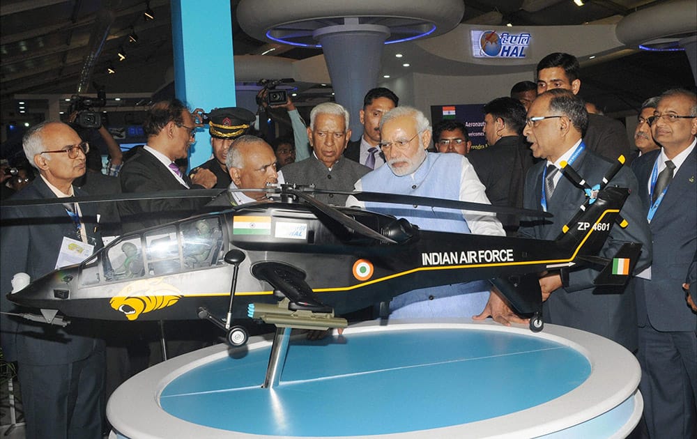 Prime Minister Narendra Modi visits a stall after the inauguration of the Aero India 2015 event at Yelhanka Air Base in Bengaluru.