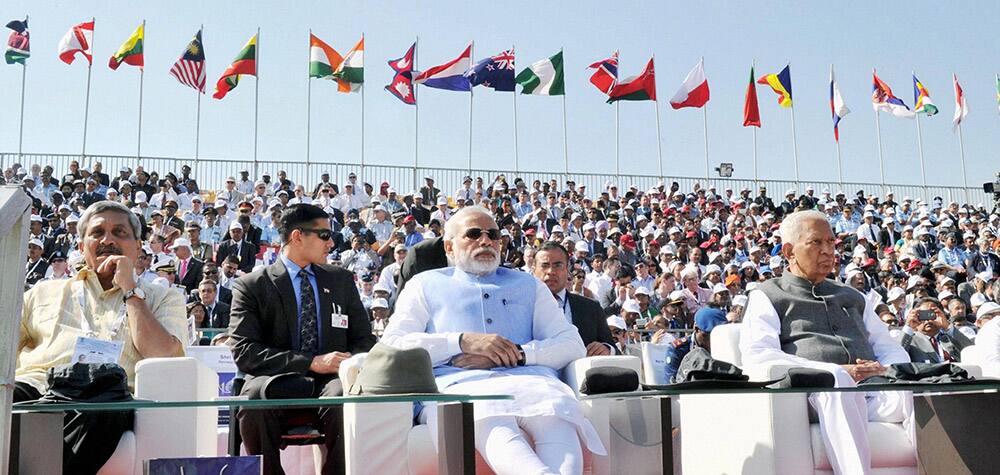 Prime Minister Narendra Modi with Defence Minister Manohar Parrikar and Karnataka Governor Vajubhai Rudabhai Vala watching the flying past display during the inauguration of the Aero India 2015, Asias Premier Air Show at Yelhanka Air Base in Bengaluru.