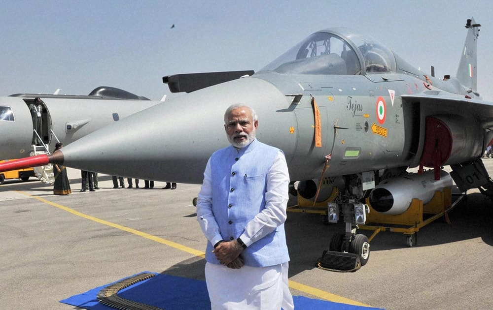 Prime Minister Narendra Modi poses for photographs during the inauguration of the Aero India 2015 event at Yelhanka Air Base in Bengaluru.