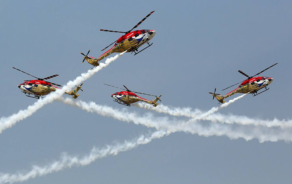 Indigenously manufactured Indian Air Force Dhruv helicopters perform aerobatic skills on the second day of Aero India 2015 at Yelahanka air base in Bangalore.