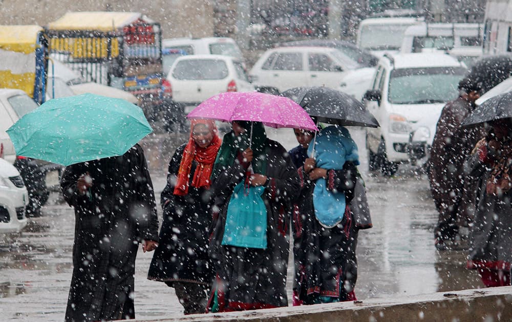 People on the streets with their umbrellas after heavy snowfall gripped Srinagar.