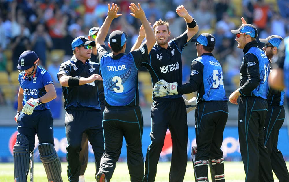 New Zealand bowler Tim Southee, centre, is congratulated by teammates after dismissing England's James Taylor, left, for no score during their Cricket World Cup match in Wellington, New Zealand.