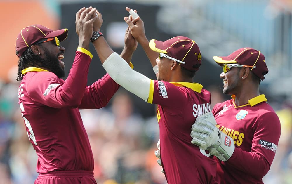 West Indies Lendl Simmons, is congratulated by teammates Chris Gayle and Denesh Ramdin after taking a catch to dismiss Pakistan's Ahmad Shahzad during their Cricket World Cup match in Christchurch, New Zealand.