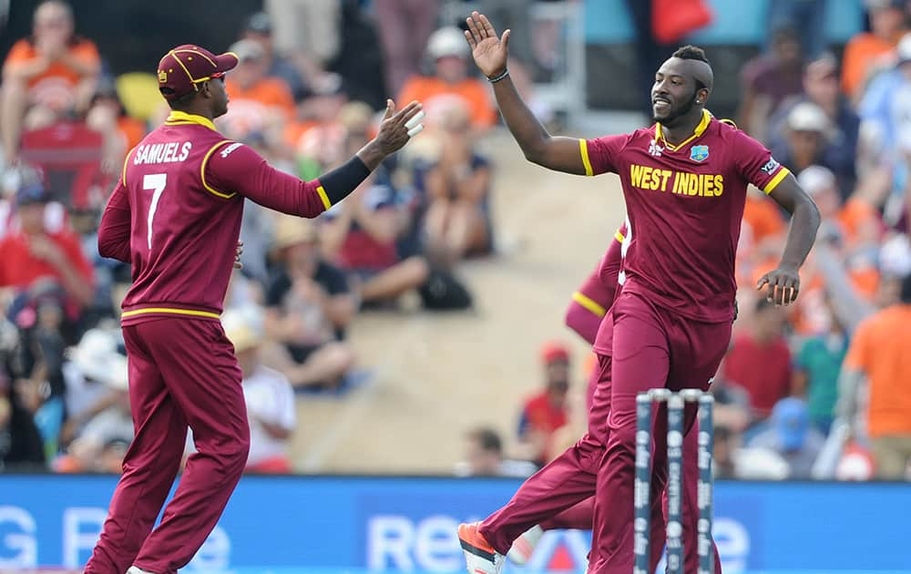 West Indies bowler Andre Russell, celebrates with teammate Marlon Samuels after dismissing Pakistan's captain Misbah Ul Haq during their Cricket World Cup match in Christchurch, New Zealand.