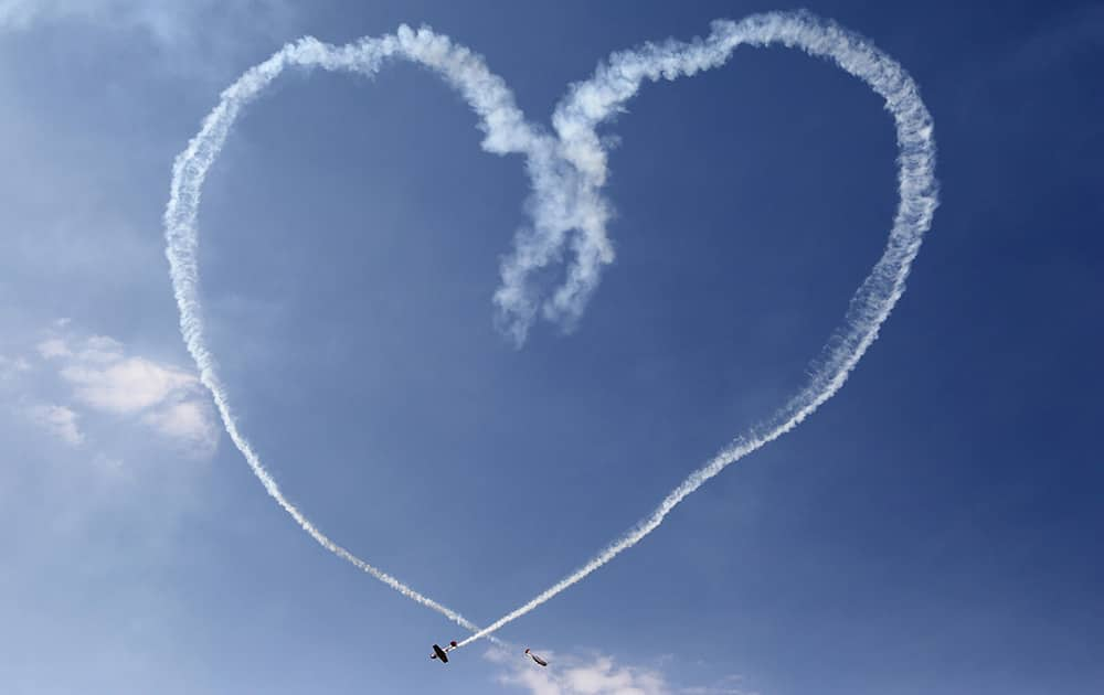 The Yakovlevs, a UK based aerobatic team flying Russian designed Yakovlev aircrafts, make a formation in the shape of a heart from a trail of smoke during the third day of Aero India 2015 at Yelahanka air base in Bangalore.