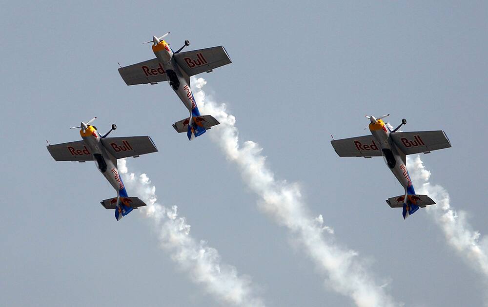 Red Bull's single-engine and single-seater aircrafts fly in a formation as they perform on the second day of Aero India 2015 at Yelahanka air base in Bangalore.