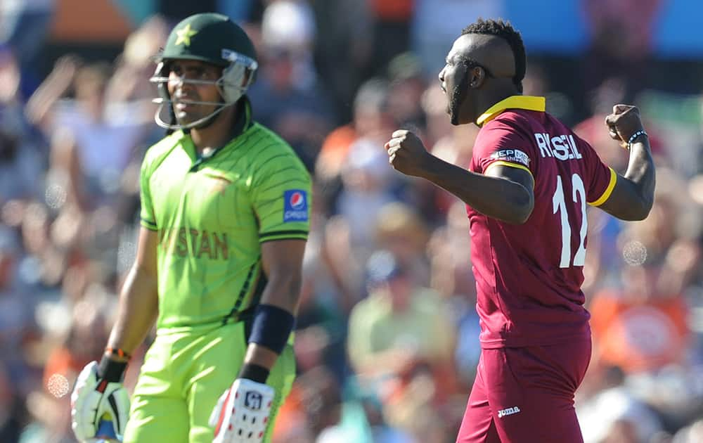 West Indies bowler Andre Russell, right, celebrates after dismissing Pakistan's Umar Akmal, left, during their Cricket World Cup match in Christchurch, New Zealand.