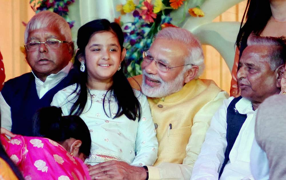 Prime Minister Narendra Modi, holding UP CM Akhilesh Yadavs daughter, attends the Tilakceremony of Tej Pratap Singh Yadav, grand-nephew of Mulayam Singh Yadav and Raj Laxmi, daughter of Lalu Prasad (R), in Saifai.