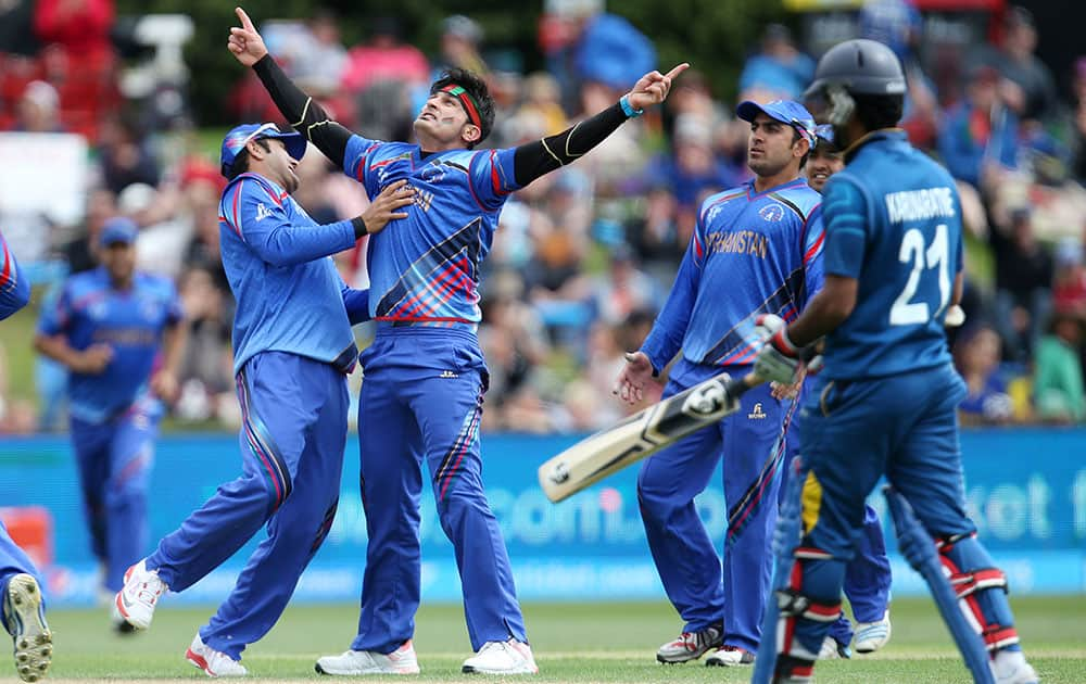 Afghanistan’s Hamid Hassan, second left, celebrates after dismissing Sri Lankan batsman Kumar Sangakkara, not pictured, during their Cricket World Cup match in Dunedin, New Zealand.