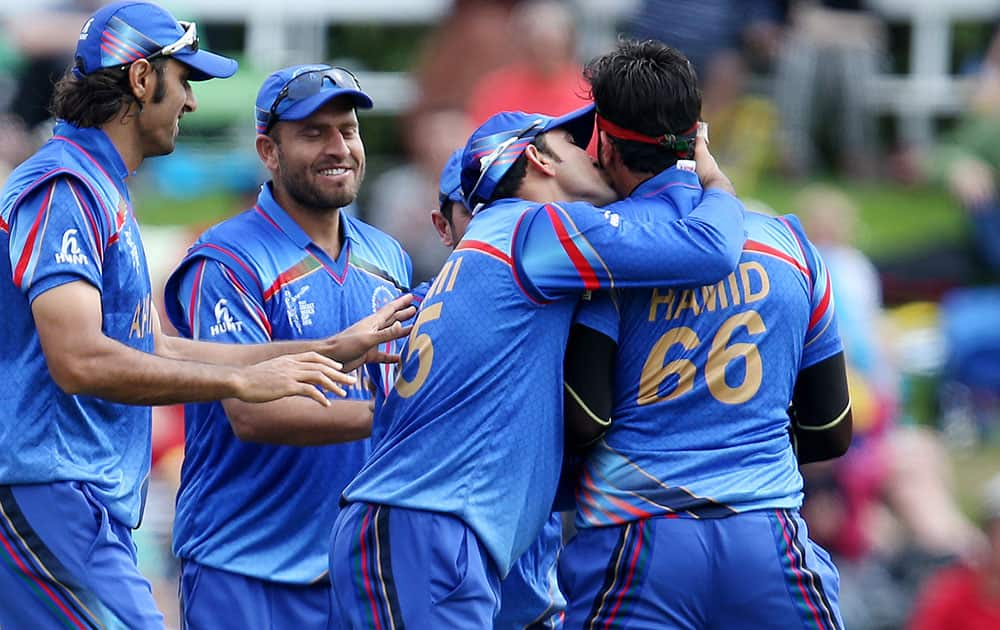 Afghanistan’s Hamid Hassan, right, is congratulated by his teammates after dismissing Sri Lanka's Kumar Sangakkara during their Cricket World Cup match in Dunedin, New Zealand.