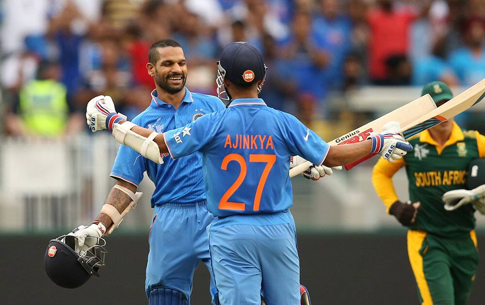 India's Shikhar Dhawan celebrates his hundred runs with teammate Ajinkya Rahane, back to camera during their Cricket World Cup pool B match against South Africa in Melbourne, Australia.