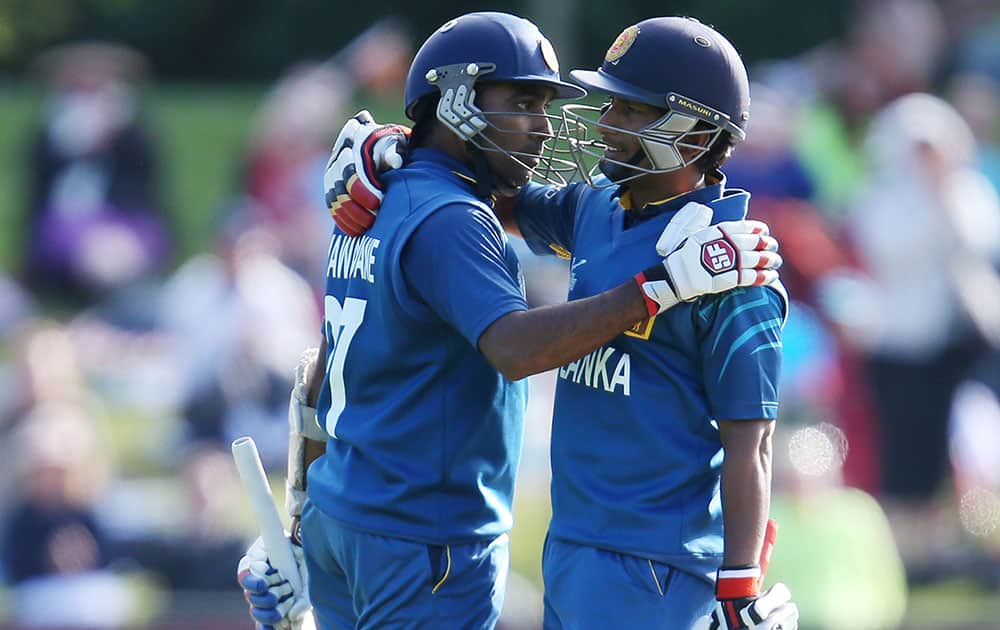 Sri Lanka's Mahela Jayawardena, left, is congratulated by teammate Jeewan Mendis after scoring century during their Cricket World Cup match against Afghanistan in Dunedin, New Zealand.