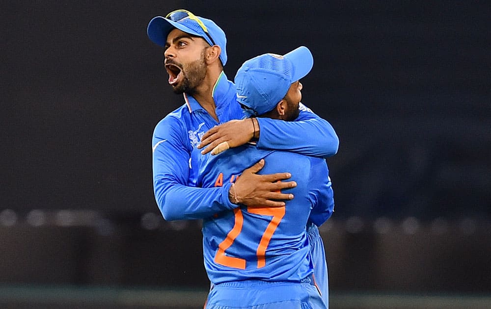 India's Virat Kohli celebrates with teammate Ajinkya Rahane after taking catch to dismiss South Africa's Quinton De Kock during their Cricket World Cup pool B match in Melbourne, Australia.