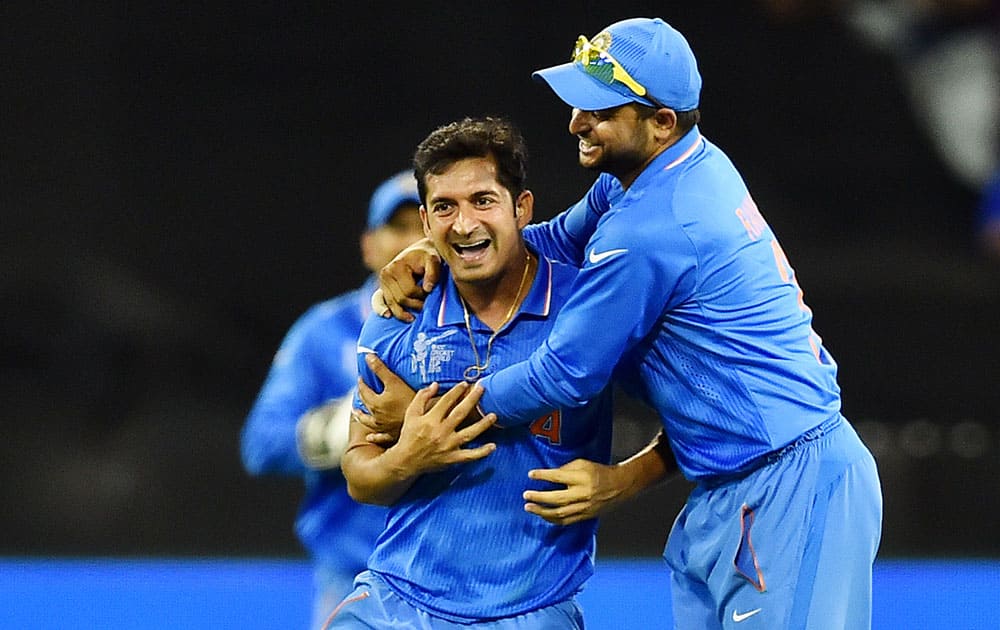 India's Mohit Sharma, left, is congratulated by teammate Suresh Raina after taking the wicket of South Africa's Francois Du Plessis during their Cricket World Cup pool B match in Melbourne, Australia.