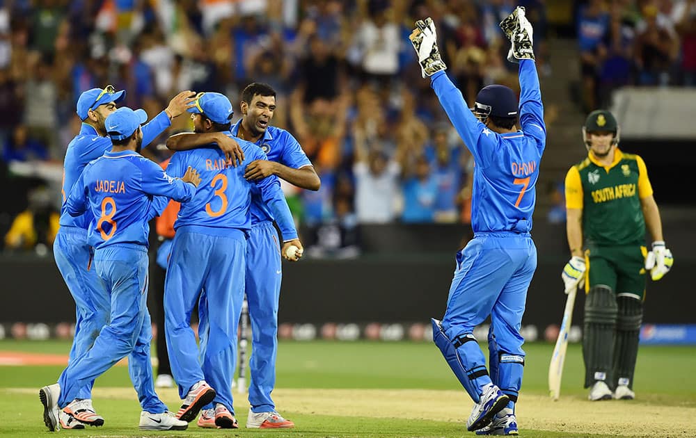 India's R Ashwin, centre, is congratulated by teammates as his captain MS Dhoni raises his arms in celebration after taking the wicket of South Africa's JP Duminy during their Cricket World Cup pool B match in Melbourne, Australia.