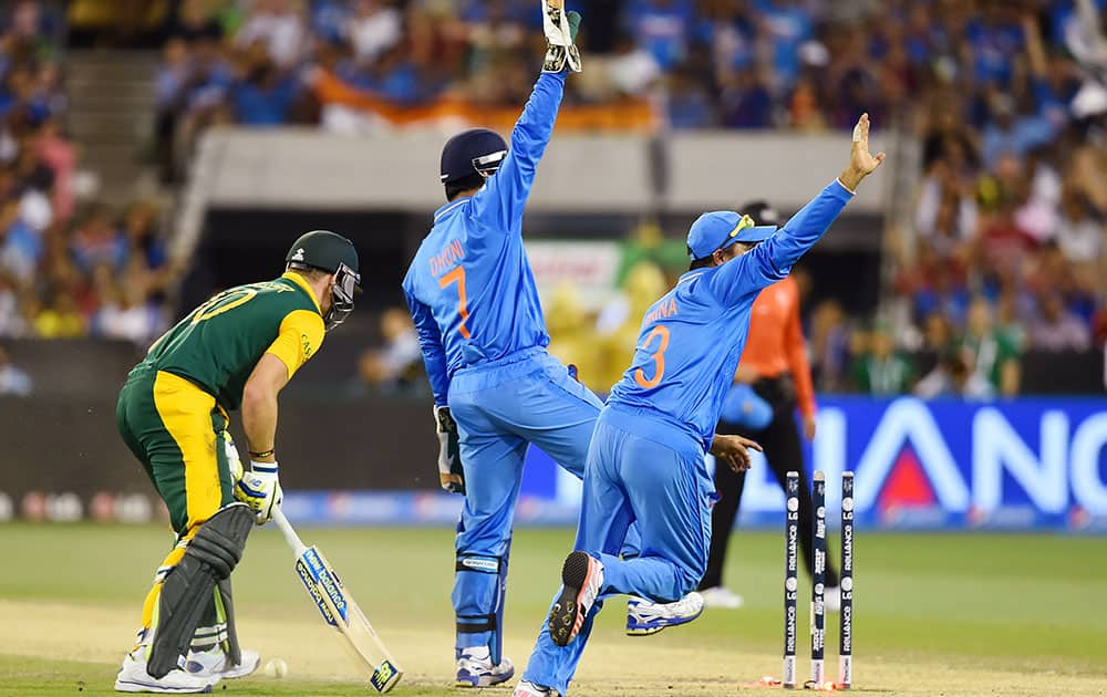 India's M S Dhoni , centre and teammate Suresh Raina celebrate after the run out of South Africa's David Miller, left, during their Cricket World Cup pool B match in Melbourne, Australia.