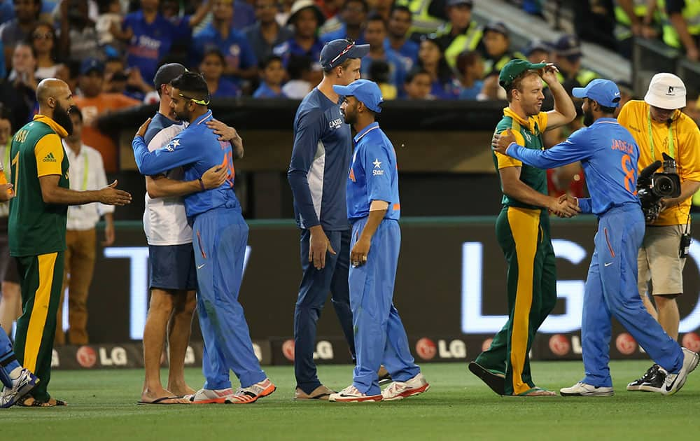 Indian players in blue, and South African players greet each other after Indian won the Cricket World Cup pool B match in Melbourne, Australia