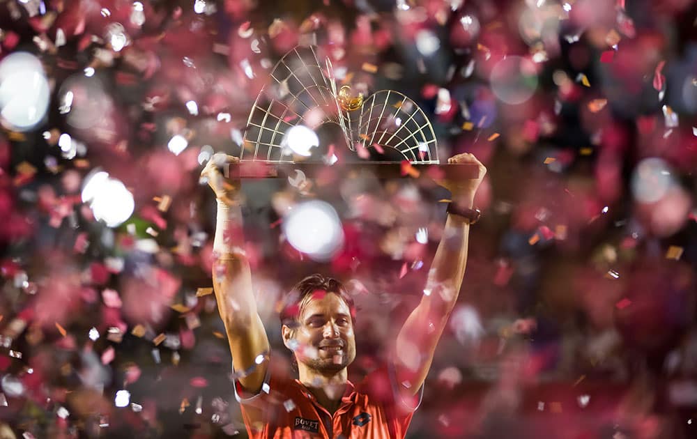 David Ferrer of Spain, holds up his trophy after defeating Fabio Fognini of Italy, 6-2, 6-3 in the men's final match of the Rio Open tennis tournament.