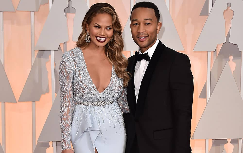 Chrissy Teigen, left, and John Legend arrive at the Oscars, at the Dolby Theatre in Los Angeles.