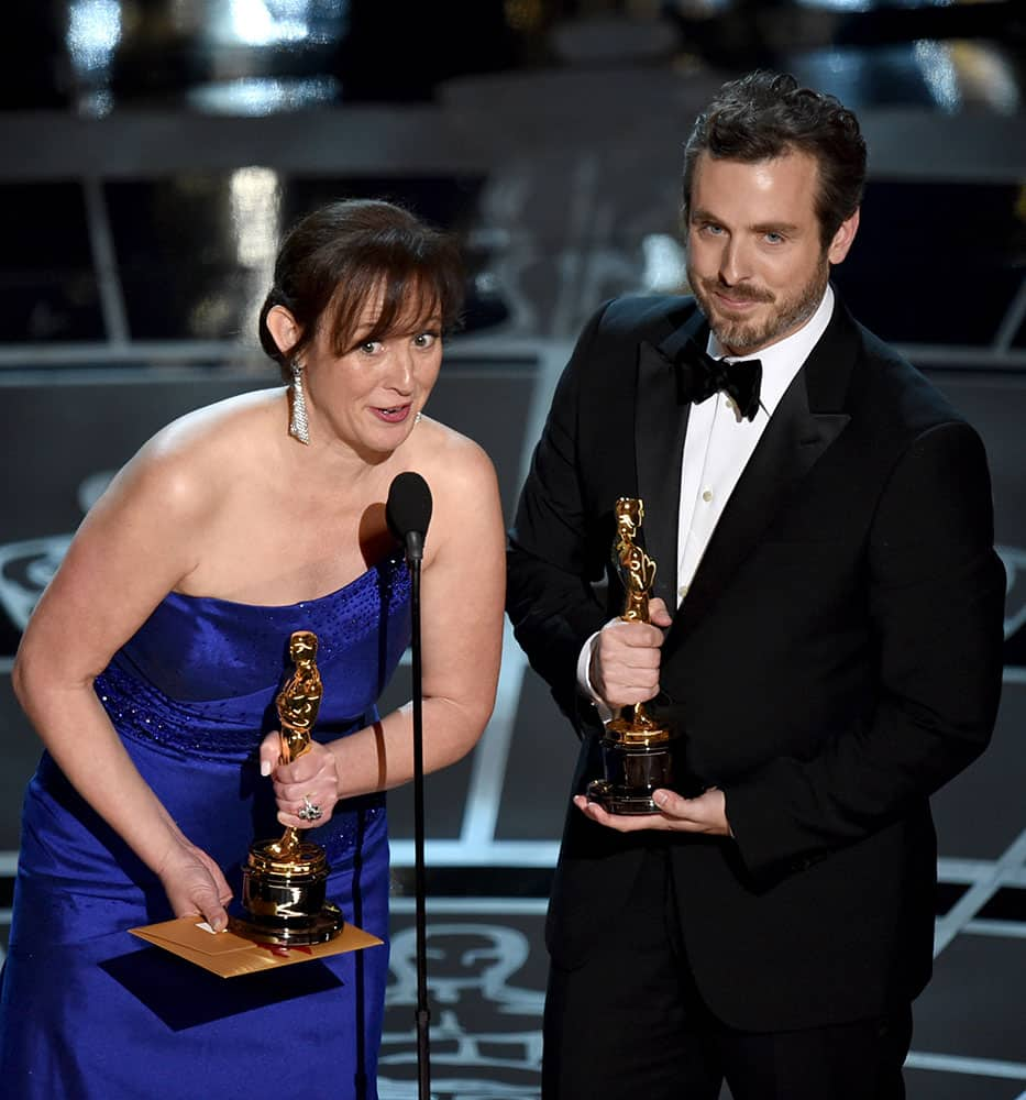 Kristina Hees, left, and Patrick Osborne accept the award for best animated short film for “Feast” at the Oscars, at the Dolby Theatre in Los Angeles.