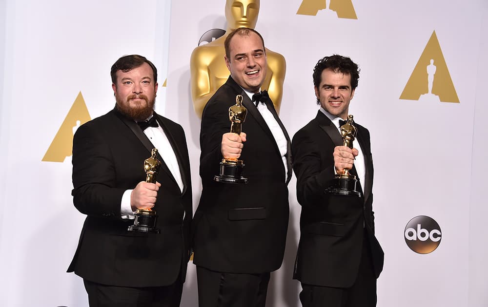 Thomas Curley, and from left, Ben Wilkins and Craig Mann pose in the press room with the award for best sound mixing for “Whiplash” at the Oscars.