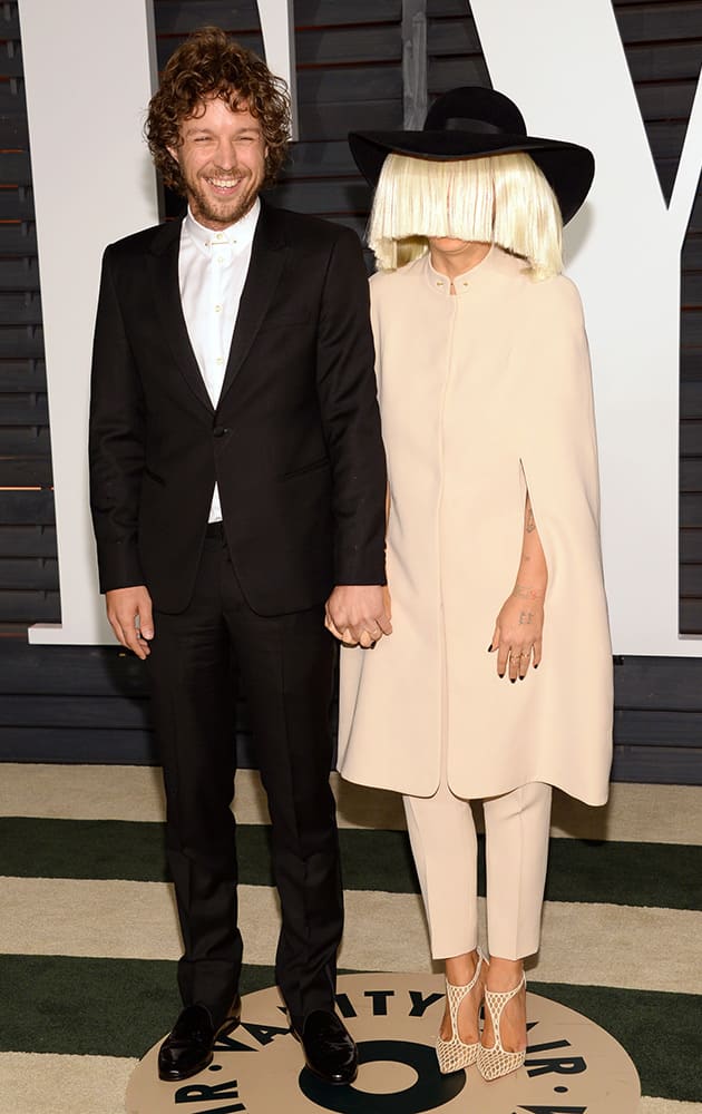 Erik Anders Lang, left, and Sia arrive at the 2015 Vanity Fair Oscar Party.