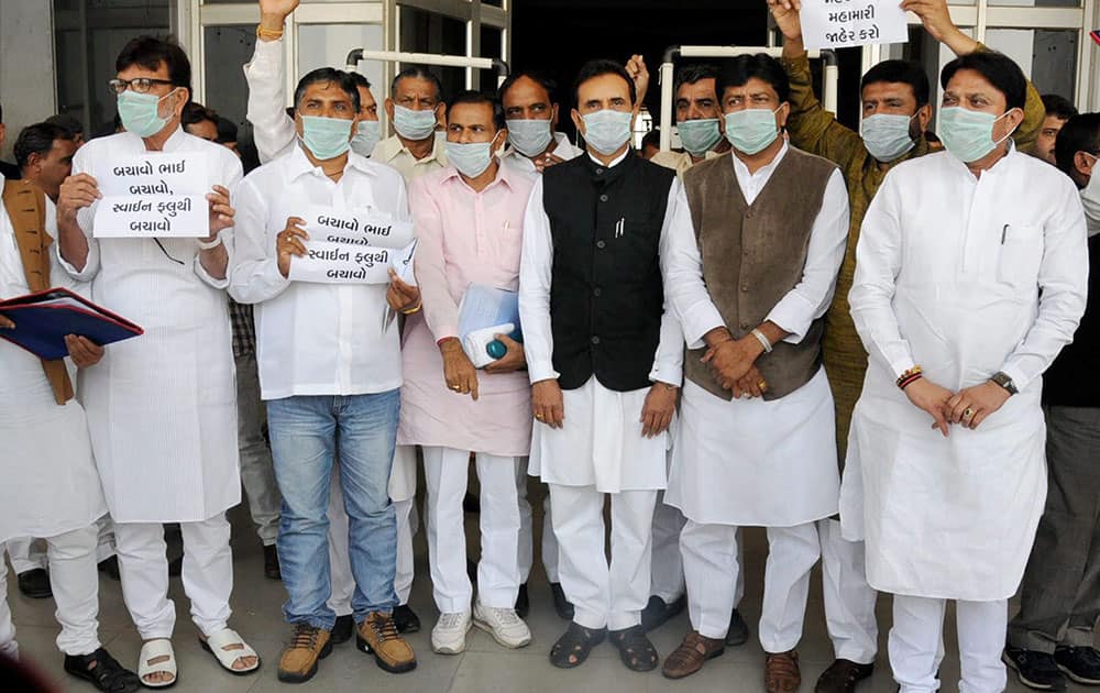 Congress MLAs hold placards and wear masks during a protest against Gujarat governments failure in controlling swine flu cases, in Gandhinagar.