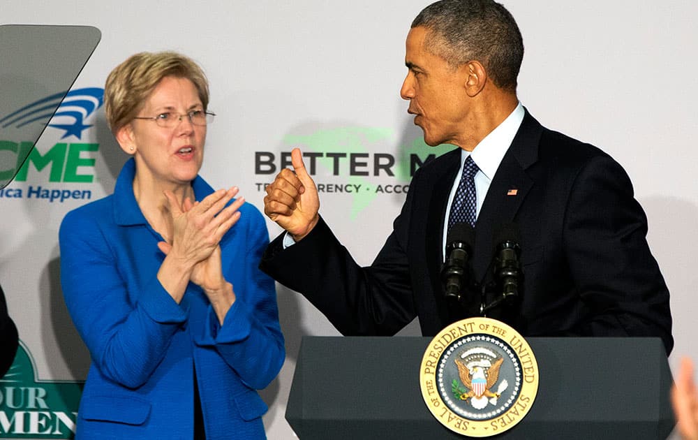 Sen. Elizabeth Warren, D-Mass. applauds as President Barack Obama makes the thumbs up sign as he arrives to speak at AARP in Washington