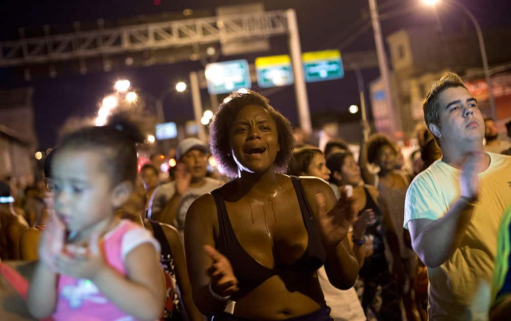 A woman shouts slogans against violence by security forces during a protest at the Mare slum, in Rio de Janeiro, Brazil.