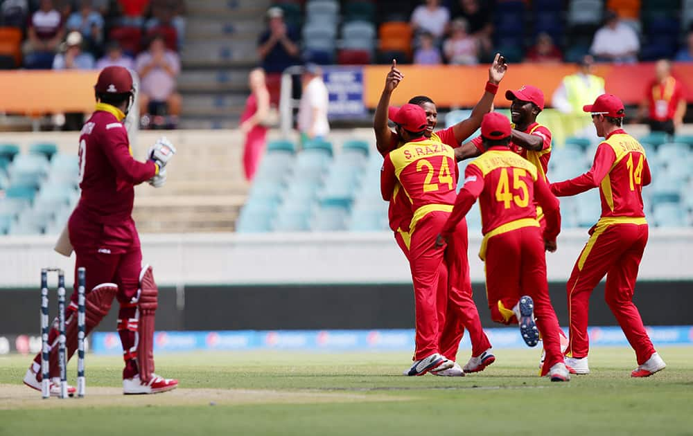 Zimbabwe's Tinashe Panyangara is congratulated by teammate's after dismissing West Indies batsman Dwayne Smith during their Cricket World Cup Pool B match in Canberra, Australia.