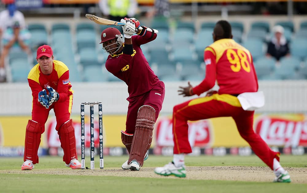 West Indies batsman Marlon Samuels plays a shot as Zimbabwe wicketkeeper Brendan Taylor and Zimbabwe's Tafadzwa Kamungozi follow the ball during their Cricket World Cup Pool B match in Canberra, Australia.