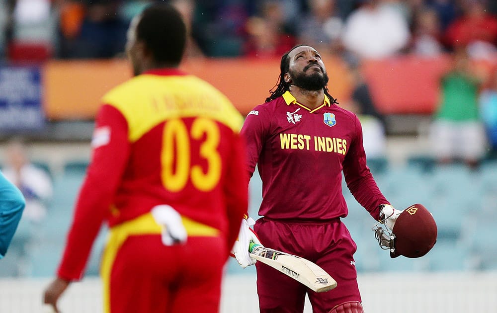 West Indies batsman Chris Gayle looks up as he celebrates after scoring a century as Zimbabwe's Hamilton Masakadza watches during their Cricket World Cup Pool B match in Canberra, Australia.