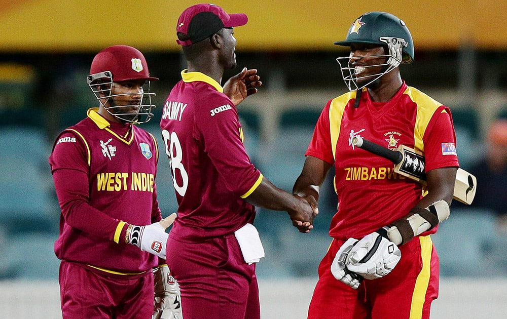 Zimbabwe's Tendai Chatara shakes hands with West Indies Darren Sammy West and Denesh Ramdin after their Cricket World Cup Pool B match in Canberra, Australia.