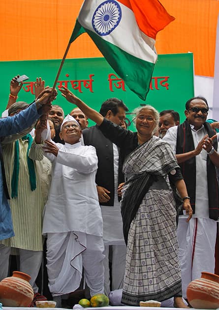 Anna Hazare and social activist Medha Patkar wave Indian flag as MDMK leader Vaiko applauds during a protest against the government’s proposed move to ease rules for acquiring land to facilitate infrastructure projects in New Delhi.