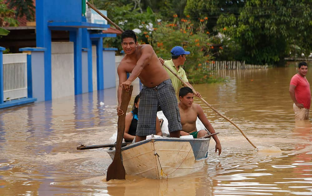 Men use a raft to navigate the flooded streets in Cobija, Bolivia.