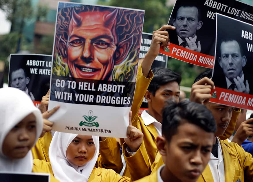 Indonesian Muslim students hold up posters during a protest against Australian Prime Minister Tony Abbott outside the Australian Embassy in Jakarta, Indonesia.