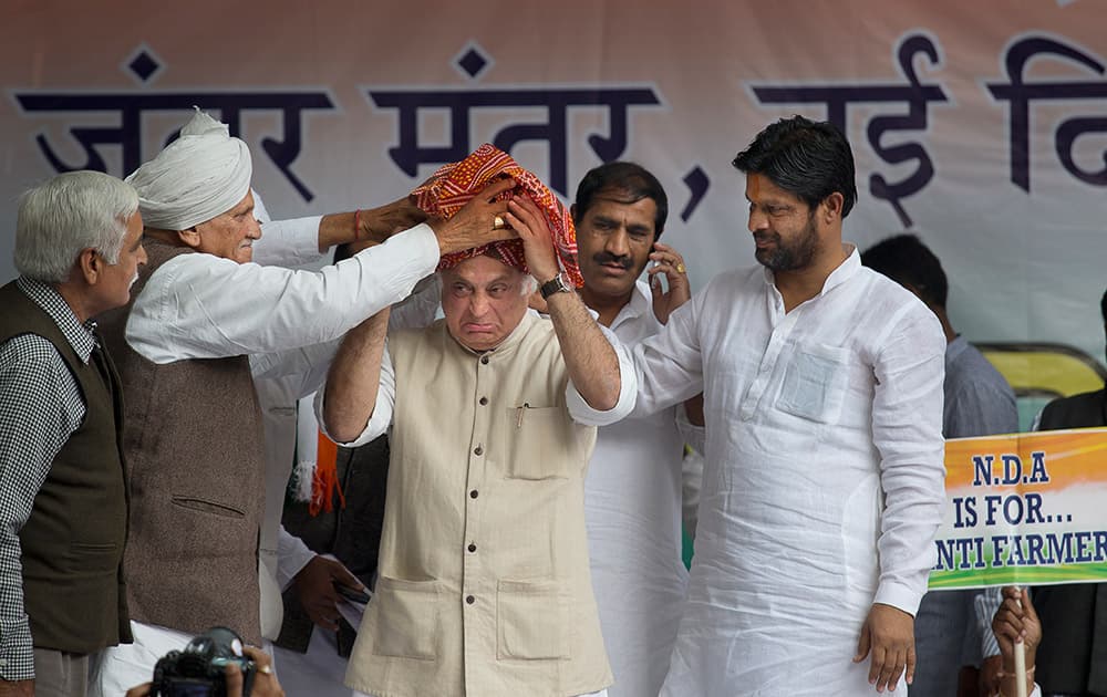 Congress party leaders tie a turban to their senior party leader Jairam Ramesh during a protest in New Delhi. The party held a mega-rally Wednesday to oppose Bharatiya Janata Party (BJP) government's land acquisition ordinance. 