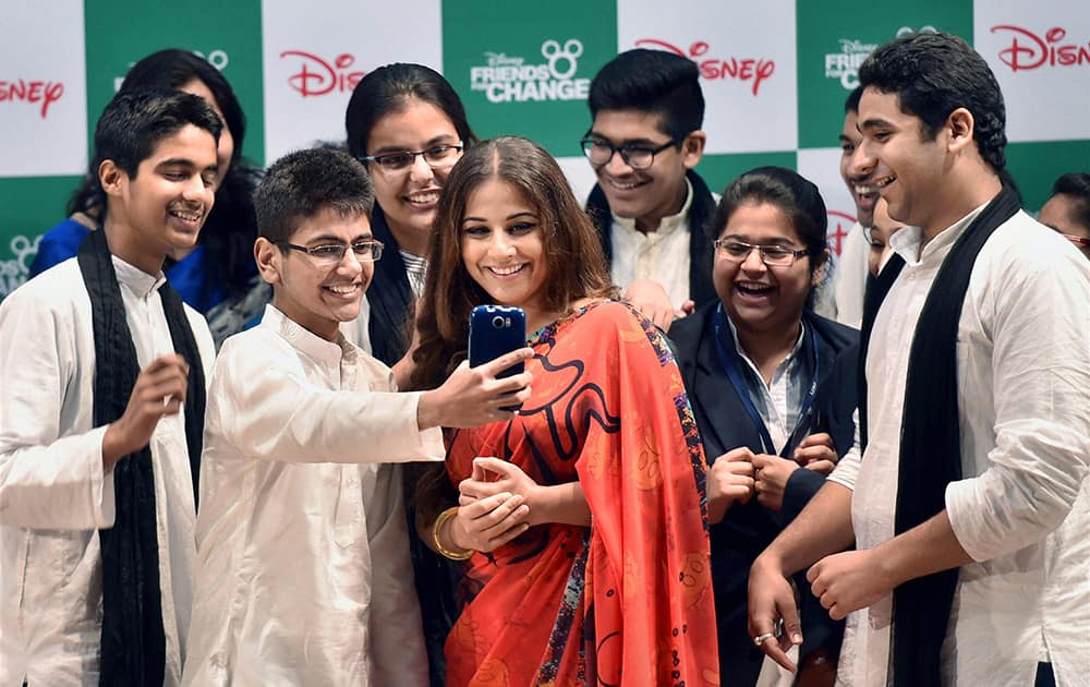 School children take selfie with Bollywood actress Vidya Balan during an event of Disney India in New Delhi.