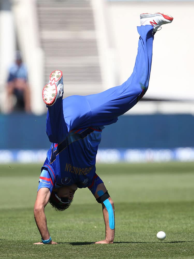 Afghanistan’s Hamid Hassan does a hand stand as he reacts after taking a catch to dismiss Scotland's Josh Davey during their Cricket World Cup Pool A match in Dunedin, New Zealand.