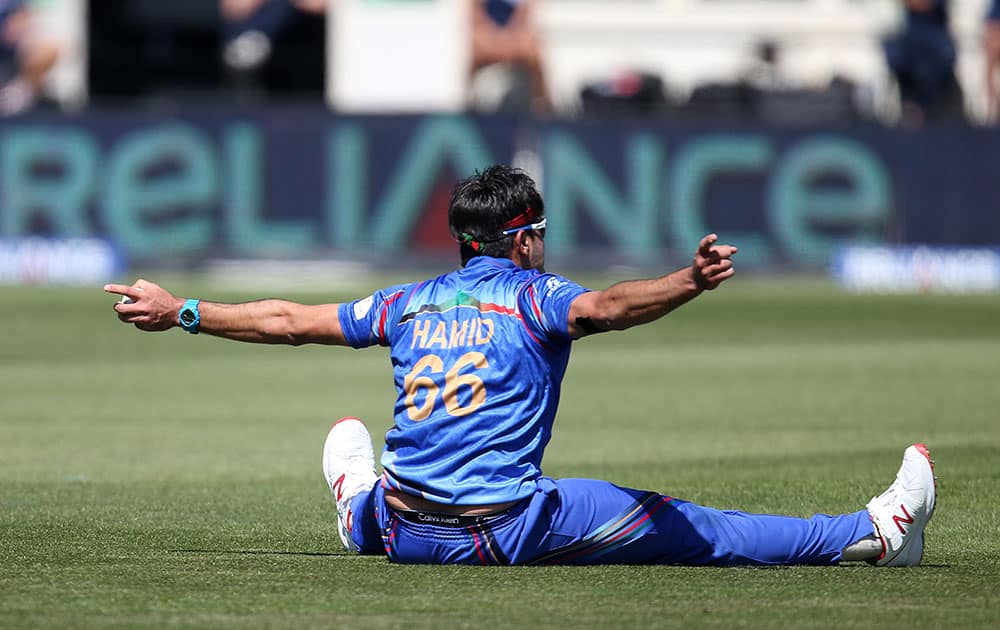 Afghanistan’s Hamid Hassan reacts after taking a catch to dismiss Scotland's Josh Davey during their Cricket World Cup Pool A match in Dunedin, New Zealand.